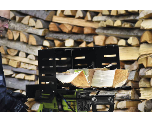 Vedklyv med vedträn framför en stapel med trä