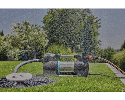 Trädgård med en trädgårdspump under rinnande vatten