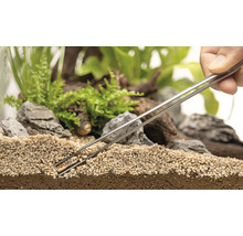 Dekorativt terrarium med växter, stenar och grus, bearbetat med pincett.