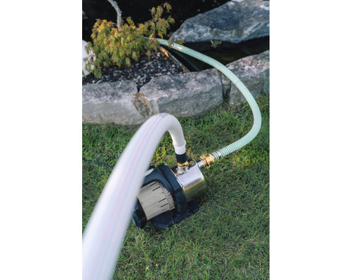 Trädgård med dammpump och slangar på gräsmatta