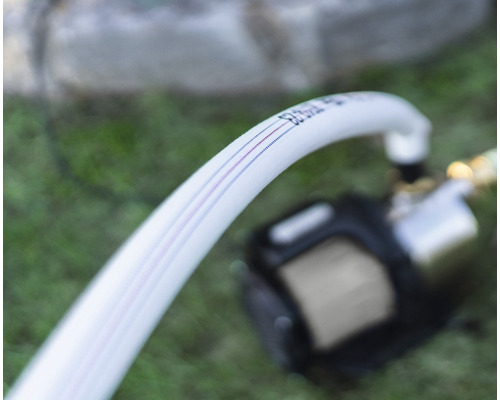 Vit bevattningsslang med färgade ränder