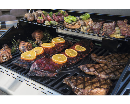 Grill med olika maträtter som revbensspjäll, biff och grönsaker.