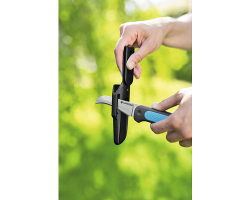 Trädgårdssax med bladskydd sätts in i skyddshölje