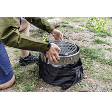 Person monterar bärbar grill utomhus