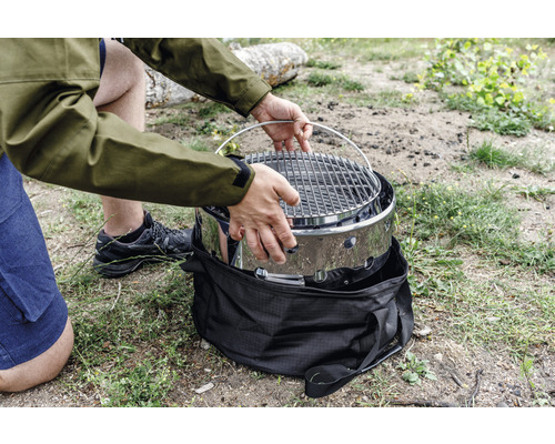 Person monterar bärbar grill utomhus