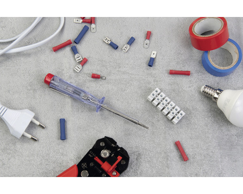 Diverse elinstallationsmaterial, inklusive hylsor, en kopplingsplint, isoleringstejp, en glödlampa, en fasprovare, en avisoleringstång och en kontakt.