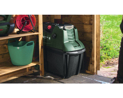 Trädgårdshackare i ett träskjul tillsammans med en hink och en kabelvinda