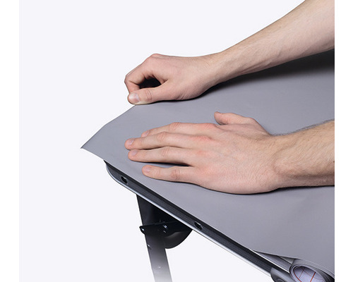 Person fäster en bordsfolie på ett bord