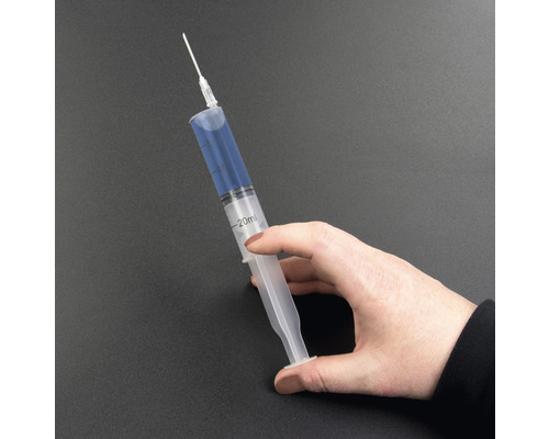 En hand håller en spruta på 20 milliliter med nål.