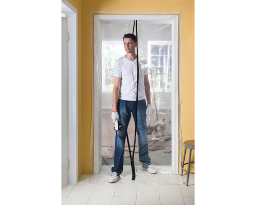 Man står i en dörröppning med dammskyddsdörr