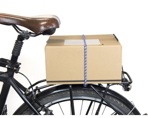 Paket på en cykelpakethållare fäst med en bagagerem.