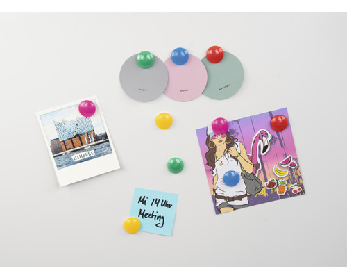 Kylskåpsmagneter håller fast anteckningar och bilder på en magnetisk yta