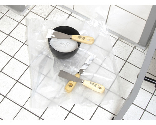 Skål med filler och två spatlar på folie