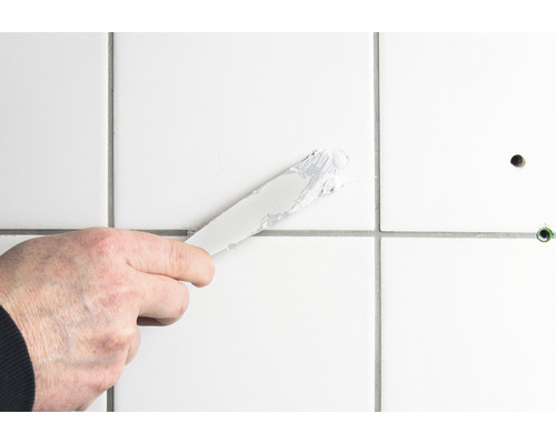 Applicera fogmassa på kakel med en spackel