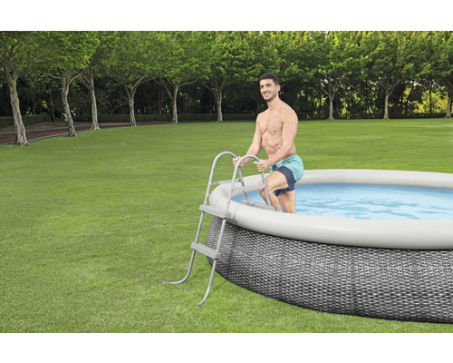 Uppblåsbar pool med stege i trädgården