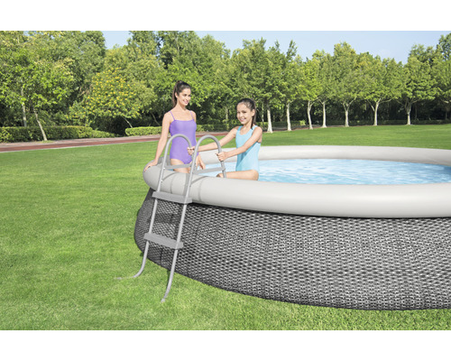 Ovanmarkspool med stege i trädgården med två personer