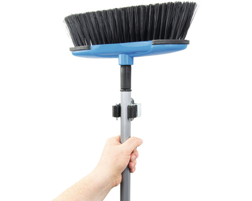 Hand håller kvast med teleskopskaft