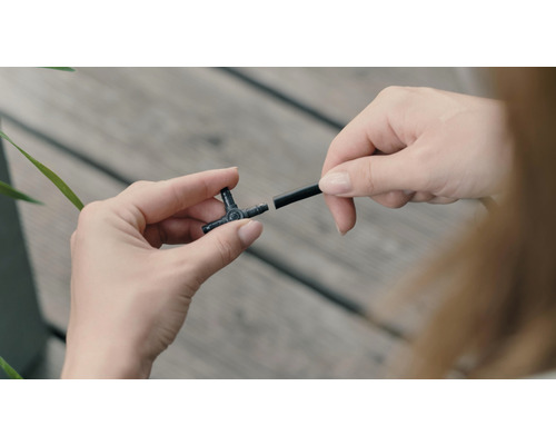 Bevattningssystem T-koppling med bevattningsslang i händerna