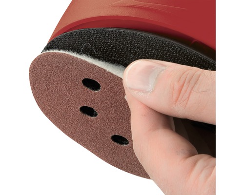 Detaljvy av sandpapper med hål, fäst på en slipmaskin