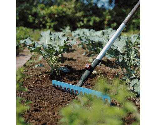 Trädgårdsscen med räfsa för att luckra upp jorden