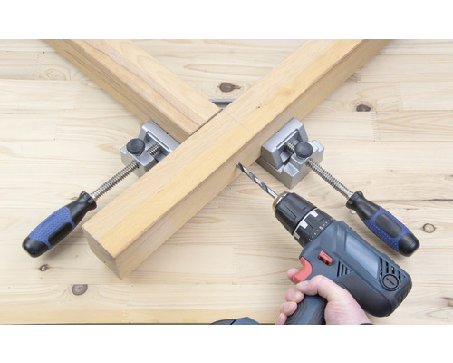 Träbearbetningsscen med borrmaskin och hörnkrok för träförbindning.