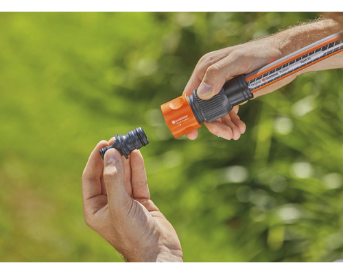 Person ansluter trädgårdsslangstycke till trädgårdsslang