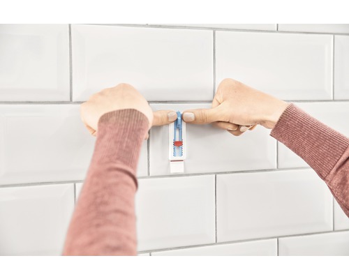 Person använder ett monteringshjälpmedel för kakel.