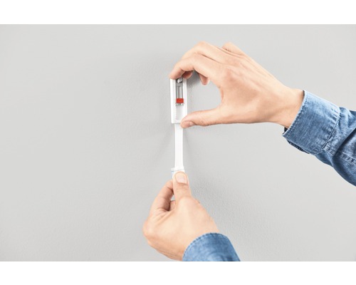 Person monterar en plugg på en vägg.