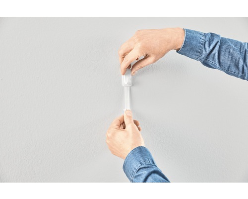 Applicering av en självhäftande remsa på en vägg.