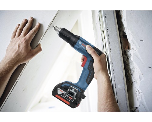 Sladdlös skruvdragare som används på en vägg med metallprofil