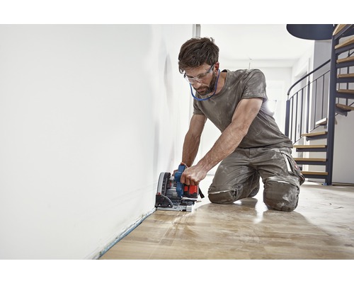 Man skär trägolv med en sänksåg.