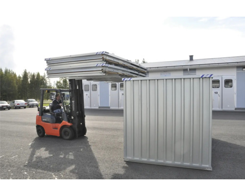 Gaffeltruck transporterar metallplattor till en byggnad