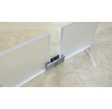 Två akrylglasskivor förbundna med en metallkoppling på en träyta