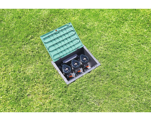 Nedgrävt sprinklersystem i gräsmatta med öppet lock