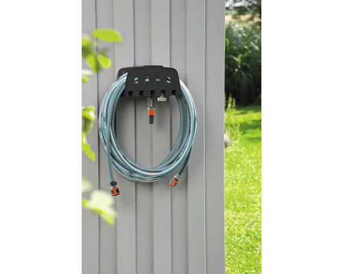 Trädgårdsslang på slanghållare på en vägg