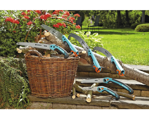Diverse handsågar från Gardena ligger med trä i en korg