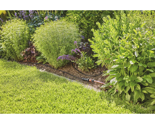 Trädgårdsbevattningssystem i en planterad trädgårdsrabatt.