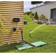 Trädgårdsscen med bevattningssystem med styrenhet, vattenkrananslutning och infällbar fyrkantig sprinkler