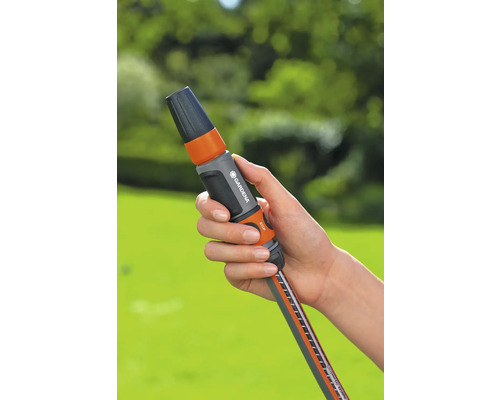 Trädgårdsslangkoppling med vattenstopp i handen