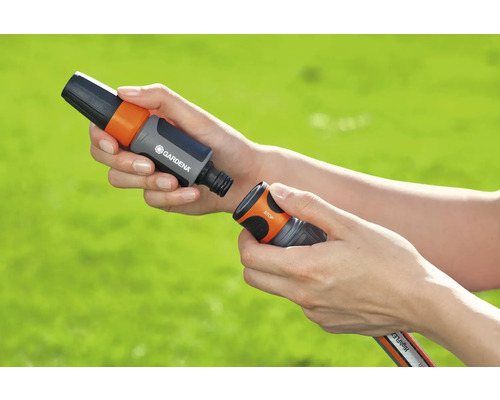 Trädgårdsslangkoppling med vattenstopp i handen