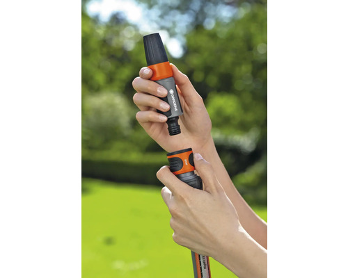 Person kopplar trädgårdsslangkoppling