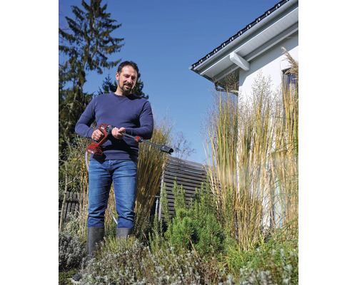 Man använder en sladdlös högtryckstvätt i trädgården.