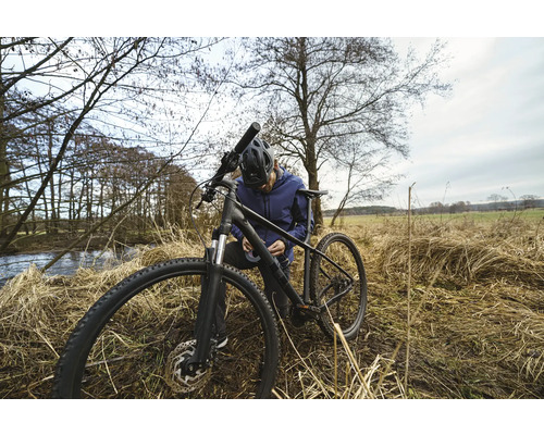 En man reparerar sin cykel i naturen