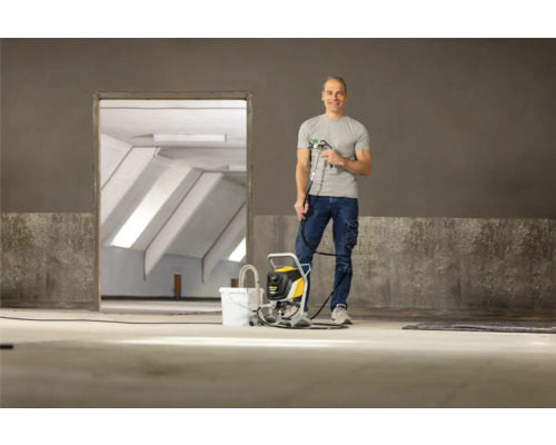 Man med färgspruta i ett tomt rum