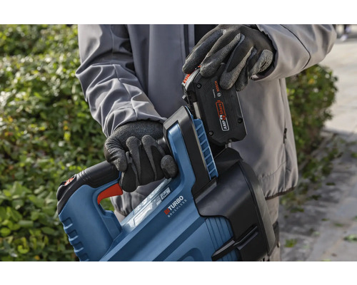 En person sätter in ett batteri i en häcksaxkropp.