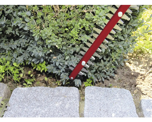 Häcksax som klipper en häck