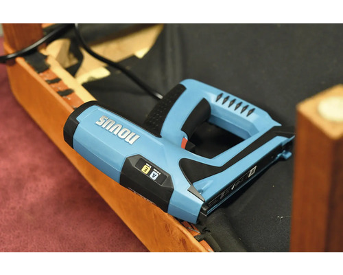 Elektrisk häftpistol av märket Novus på en möbel