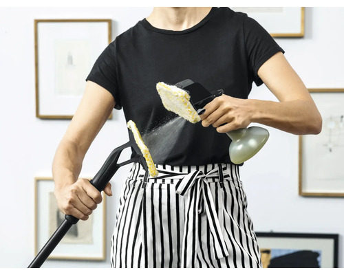 Kvinna använder en ångrengörare med olika tillbehör för rengöring