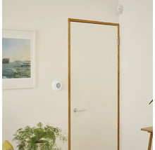 Interiörbild av ett rum med dörr, rörelsesensor och bild