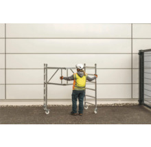 Byggnadsarbetare skjuter en rullställning.